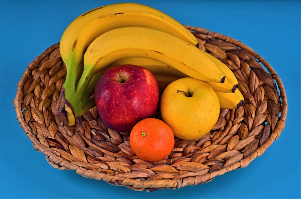 Whole fresh fruit splashing in water — apples, strawberries and kiwi, clean and unprocessed
