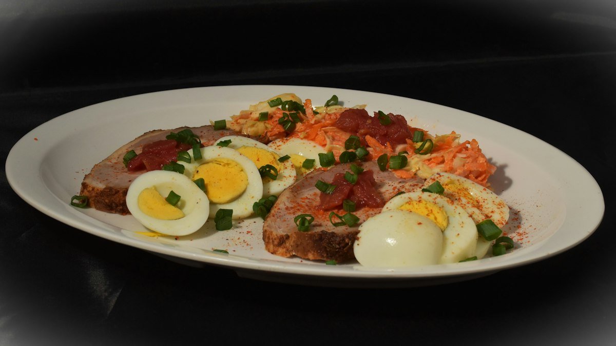 A RestoreFit dinner bowl with sliced steak, egg and colorful vegetables — cucumber, tomato and corn